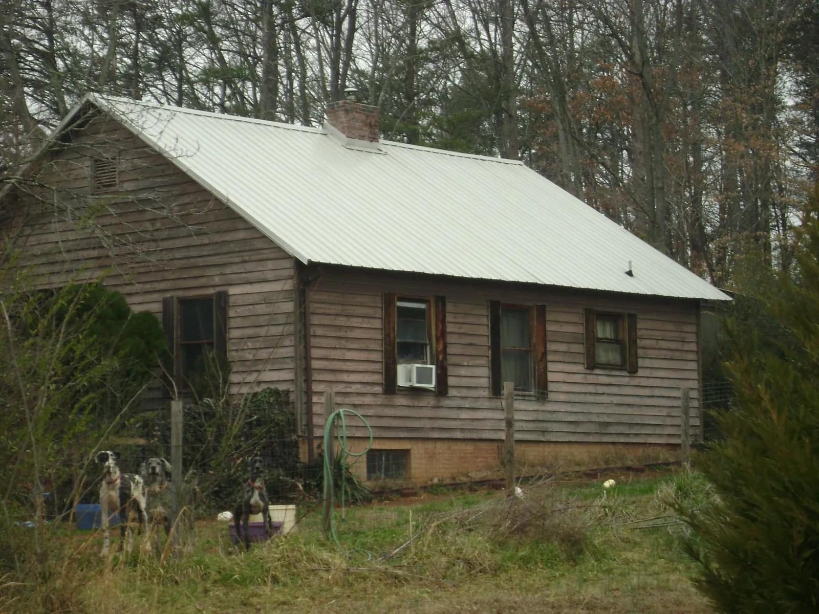 White metal roof on an old wood sided farmhouse, from a Metal Roof Installation job in Bedias